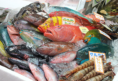 第一牧志公設市場。那霸市。小商店鱗次櫛比,南國色彩鮮豔的魚、島蔬菜、豬肉塊等狹窄的地方排列著。